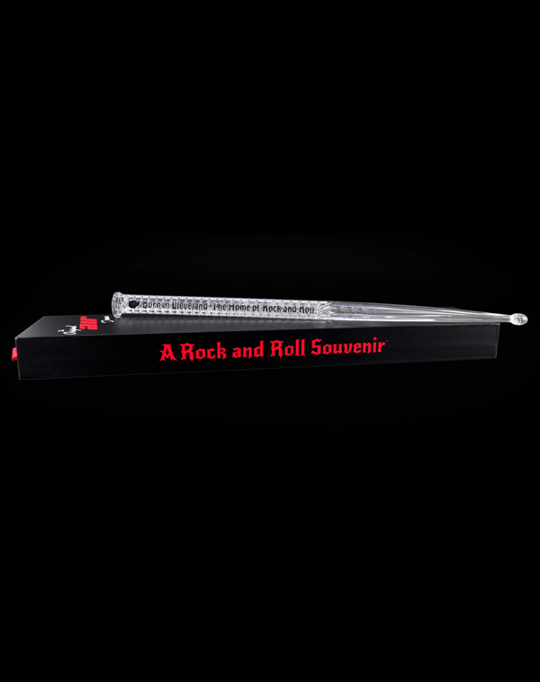 Authentic Original Air Drums stick resting on its black presentation box with red branding